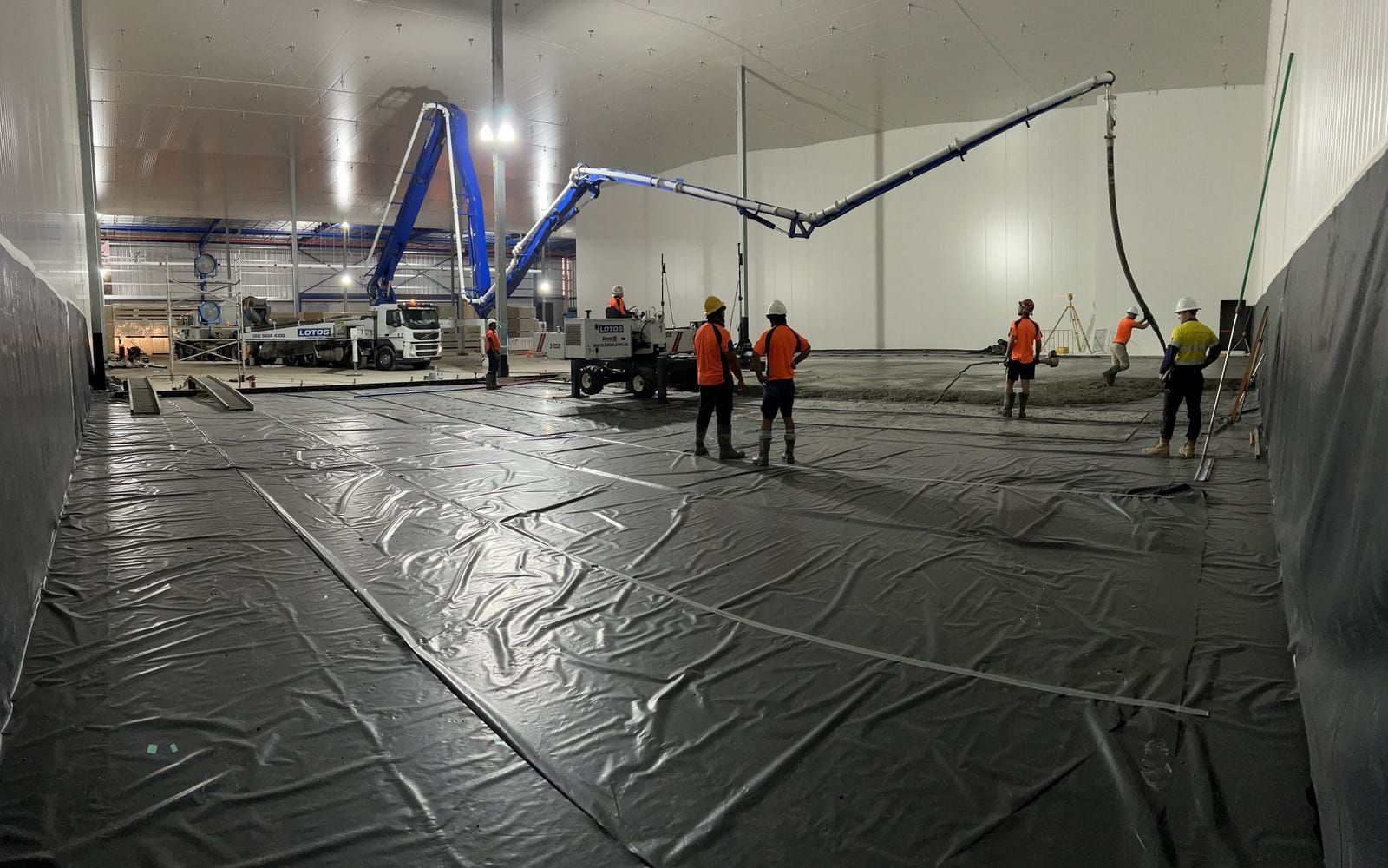 A boom pump placing a slab inside an insulated freezer chamber