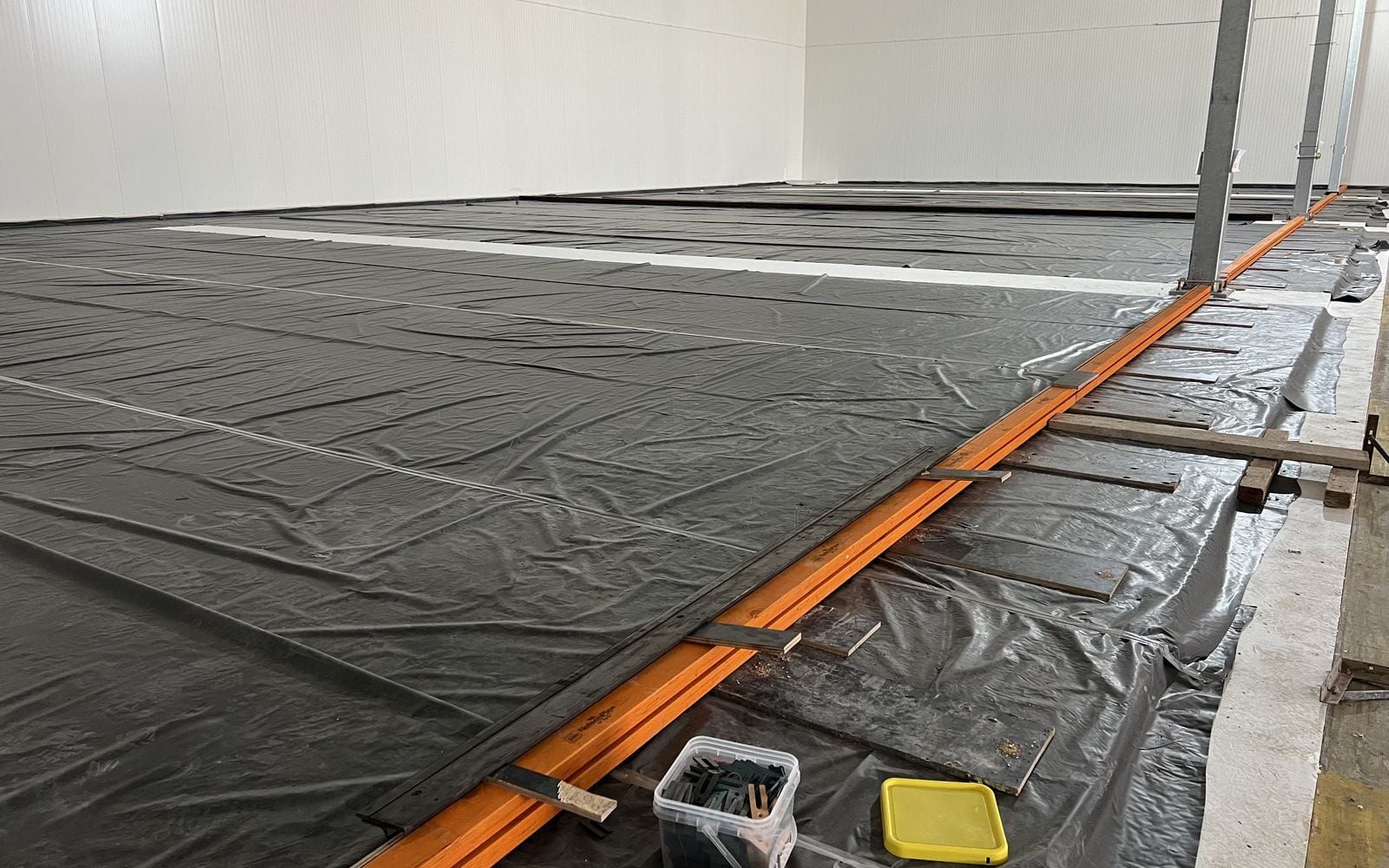 Membrane laid out across the floor of an insulated freezer chamber
