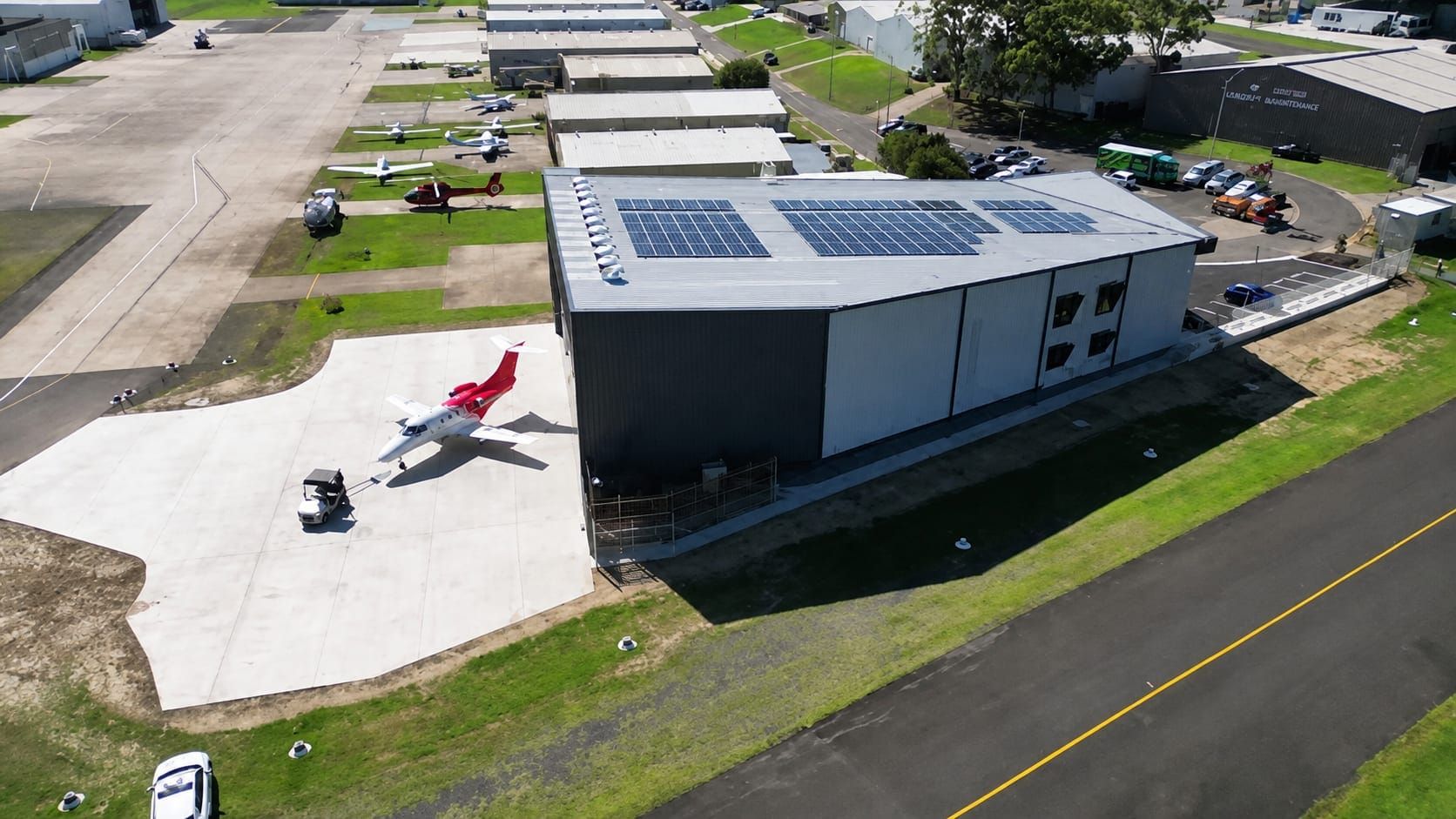 Completed aircraft hangar with apron pavement and parked private jet